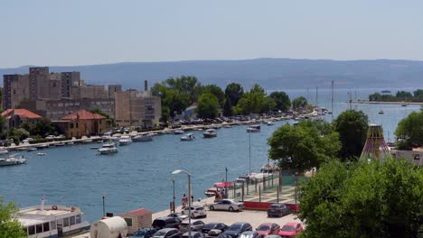 omish river in croatia on a sunny day with a clear sky, featuring boats and people enjoying the tranquil waterside atmosphere