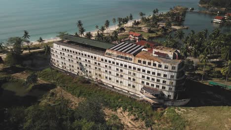 aerial drone view of an old land locked ferry boat in a lagoon, drone descending from the air over the building, ship like structure in a lagoon, bird view of the drone descending down from the air