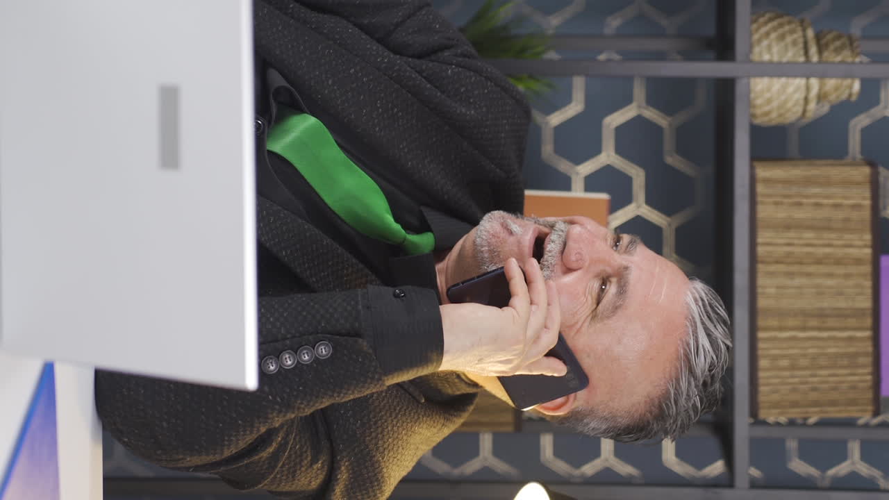 사업가가 전화로 좋은 소식을 듣는 수직 비디오입니다.