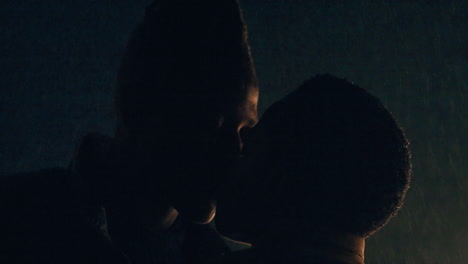 Silhouette-Eines-Jungen-Afroamerikanischen-Paares,-Das-Sich-Im-Regen-Küsst-Und-Händchen-Hält-Und-Nachts-Auf-Einem-Wunderschönen-Dach-Eine-Romantische-Verbindung-Genießt