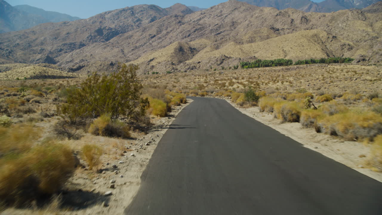 Palm Springs empty road driving pov with the rugged San Jacinto Mountains rising behind them in California