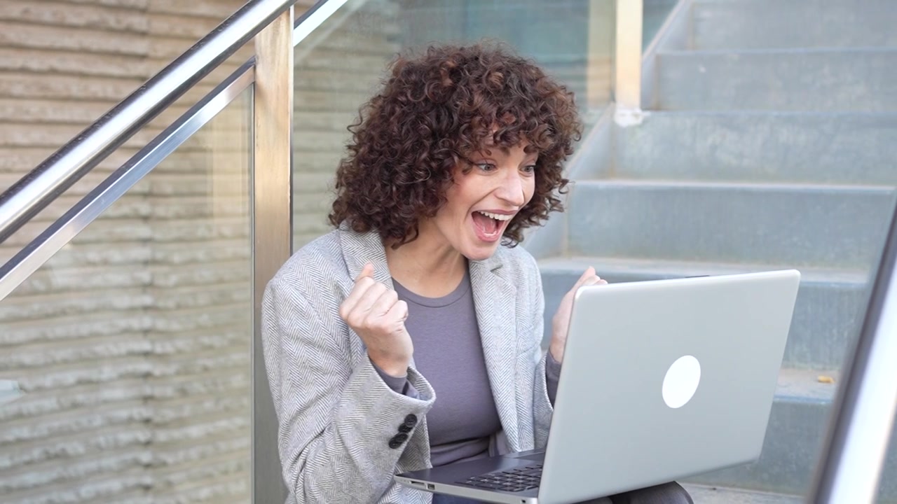 Un professionista concentrato e dedicato lavora al laptop mentre è seduto all'aperto nella natura.