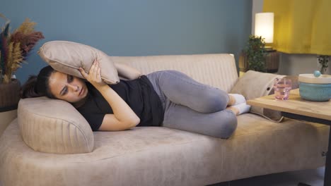 The-young-woman-who-presses-the-pillows-on-her-head-with-fear.