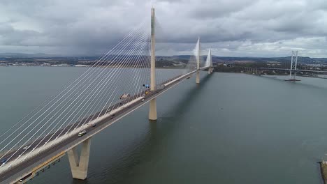 rising drone footage showing queensferry crossing, scotland on cloudy overcast day.