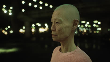 old-Asian-woman-in-city-at-night