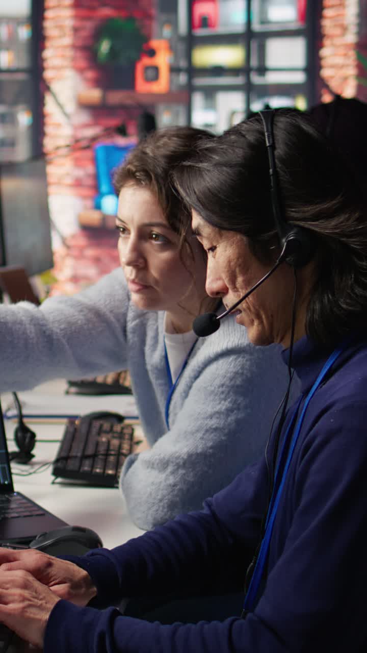 Vertical video Call center manager supervising work done by agent helping customers