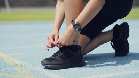 closeup of runner tying shoe laces before running