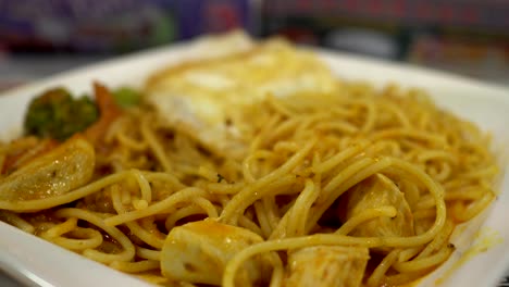 close up on spaghetti in the restaurant. blurred background is a little girl having a meal.