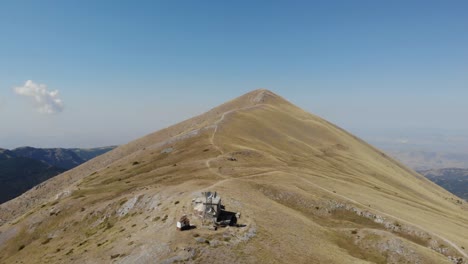 AERIAL:-Flying-over-Kissavos-Mountain-in-Greece-top-revealing-the-beautiful-landscapes-,-drone-day-shot,-clean-sunny-sky-camera-slowly-moving-away-from-the-peak