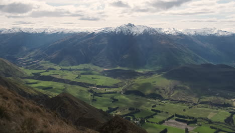 valle agrícola verde entre montañas nevadas