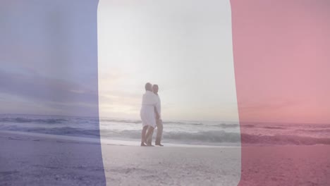 Animación-De-La-Bandera-De-Francia-Sobre-Una-Pareja-Birracial-Mayor-Caminando-En-La-Playa.