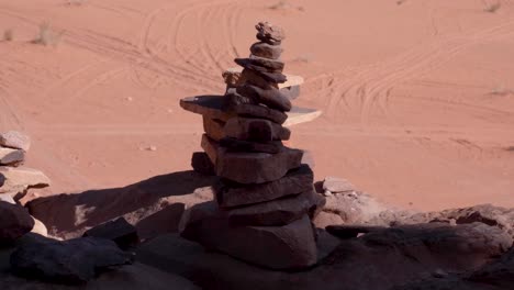 una pila de rocas y piedras apiladas con vistas al vasto y árido paisaje desértico de wadi rum en jordania, oriente medio