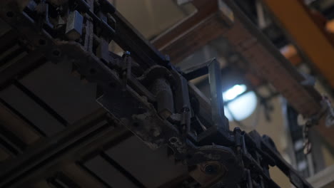 heavy load swinging from a industrial crane in a manufacturing plant