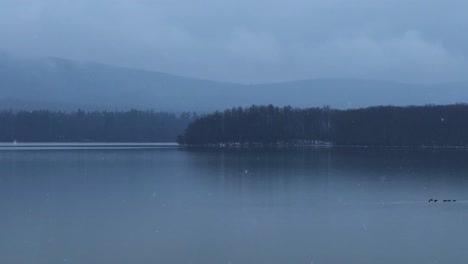 beautiful and calm gentle snowfall over a calm, quiet mountain lake