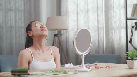 mujer aplicando una máscara ocular de pepino