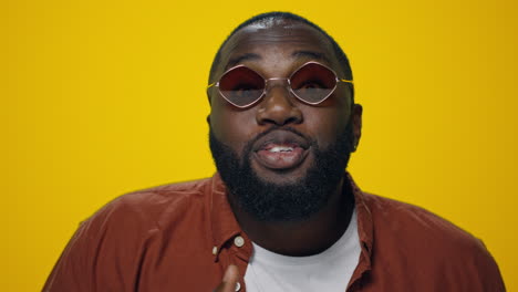 portrait of happy african american man showing yes gesture on yellow background,