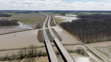 flooded area in southern indiana farmland next to freeway with drone video wide shot moving forward showing cars