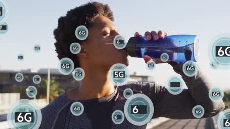 animation of 5g texts over african american man drinking water