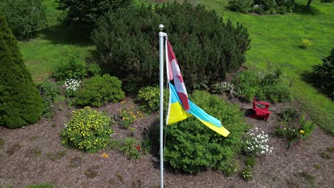 canadian flag and ukrainian flag flying together on flagpole in solidarity and symbolic alliance during war time