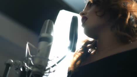 woman singing in the recording studio. profile of a woman with a beautiful face and lips.