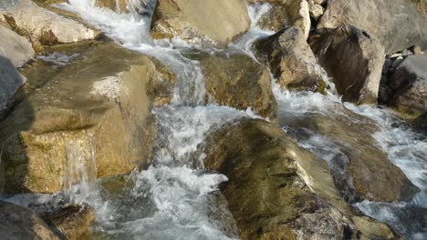 a crystal-clear mountain river cascades over rugged rocks in the swiss alps, region of amden, capturing the beauty of alpine nature.