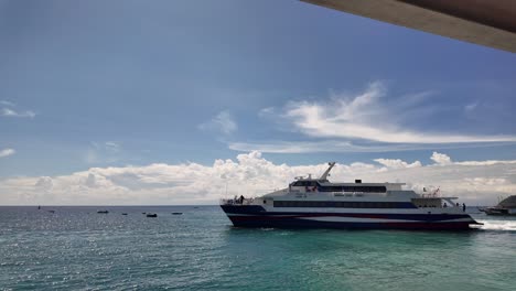 a ferry speedboat leaves the marina harbor in koh tao under a sunny sky, with calm ocean waters and scenic surroundings