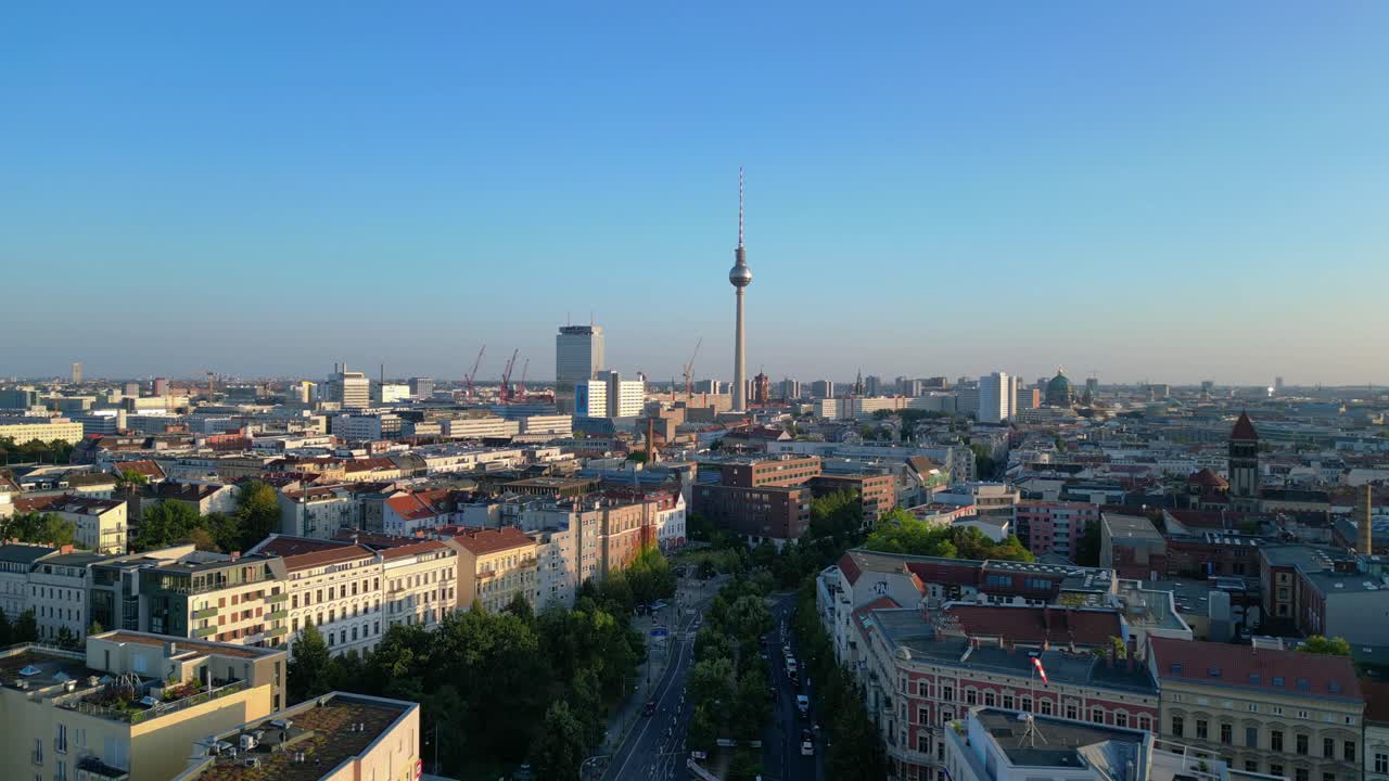 Berlin tv tower rising above rooftops and a construction site at senefelderplatz during sunset. Lovely aerial view flight speed ramp hyper motion time lapse
