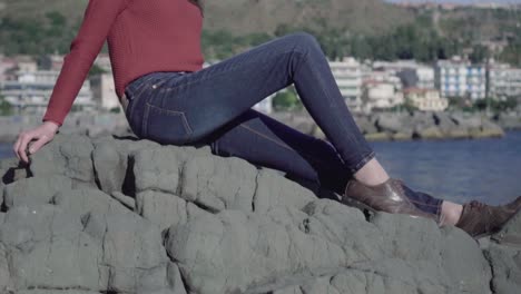 chica con gafas de sol sobre las rocas admira la vista