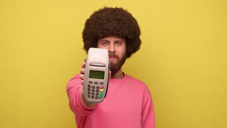 hombre con una terminal de pago sin contacto en la mano, usando paypass para el pago de compras.