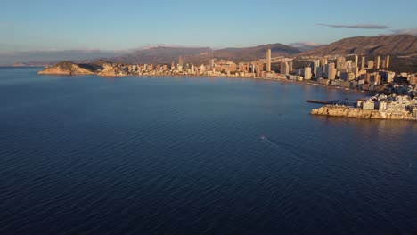 Luftaufnahme-Der-Bucht-Von-Benidorm-Mit-Wolkenkratzern-Am-Wasser-Bei-Sonnenuntergang