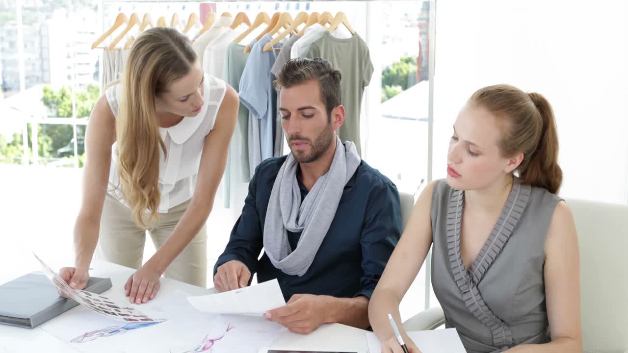 패션 디자인 팀 이 테이블 에서 함께 일 하고 있다