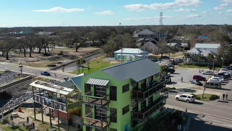 Aerial-approach-of-eateries,-bars-and-pigeons-resting-on-a-tin-roof-in-Bay-Saint-Louis,-Mississippi