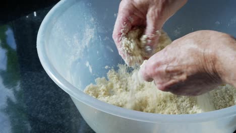 woman mixes flour and butter in a large mixing bowl to make pastry