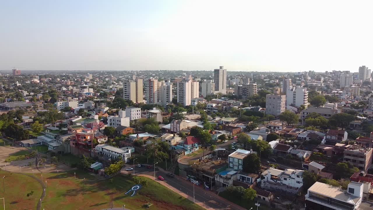 imágenes aéreas de drones del horizonte de una gran ciudad cerca de un parque al atardecer en posadas, misiones, argentina