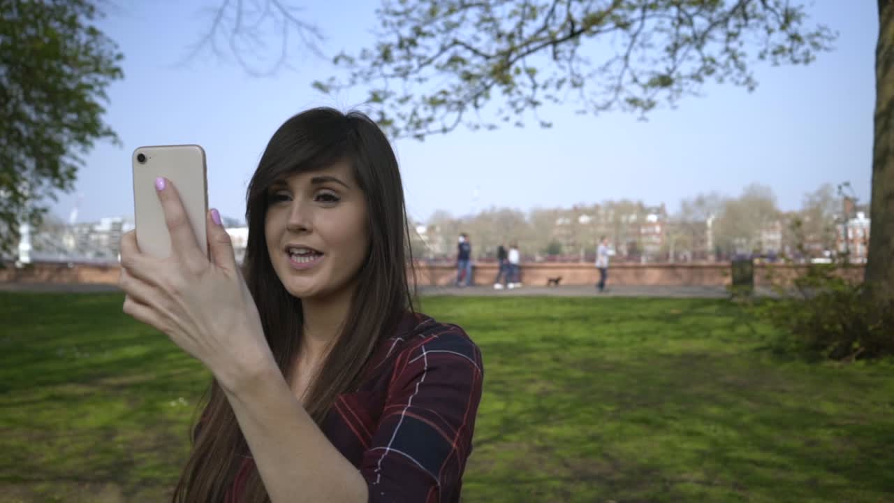 mujer haciendo una llamada de facetime en un parque
