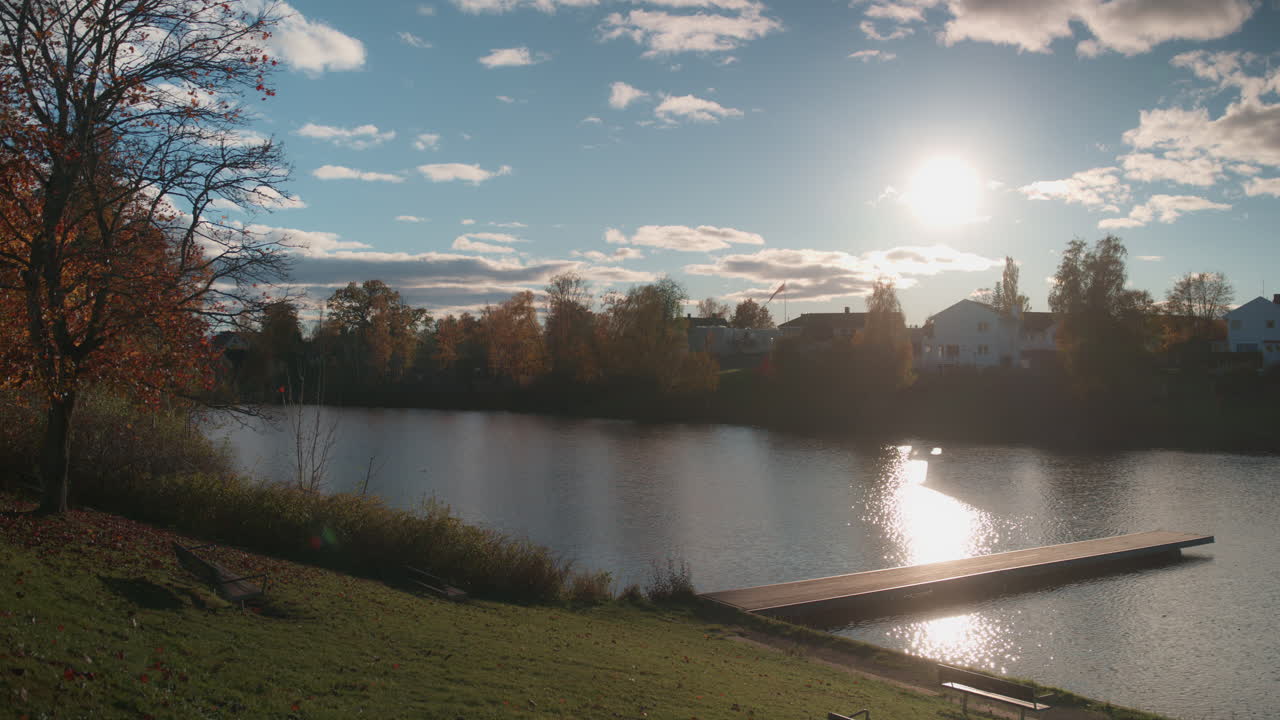 Wide shot of a lake in Oslo, Norway with a small pier on a sunny October day