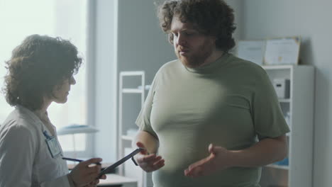 doctor consults with obese patient