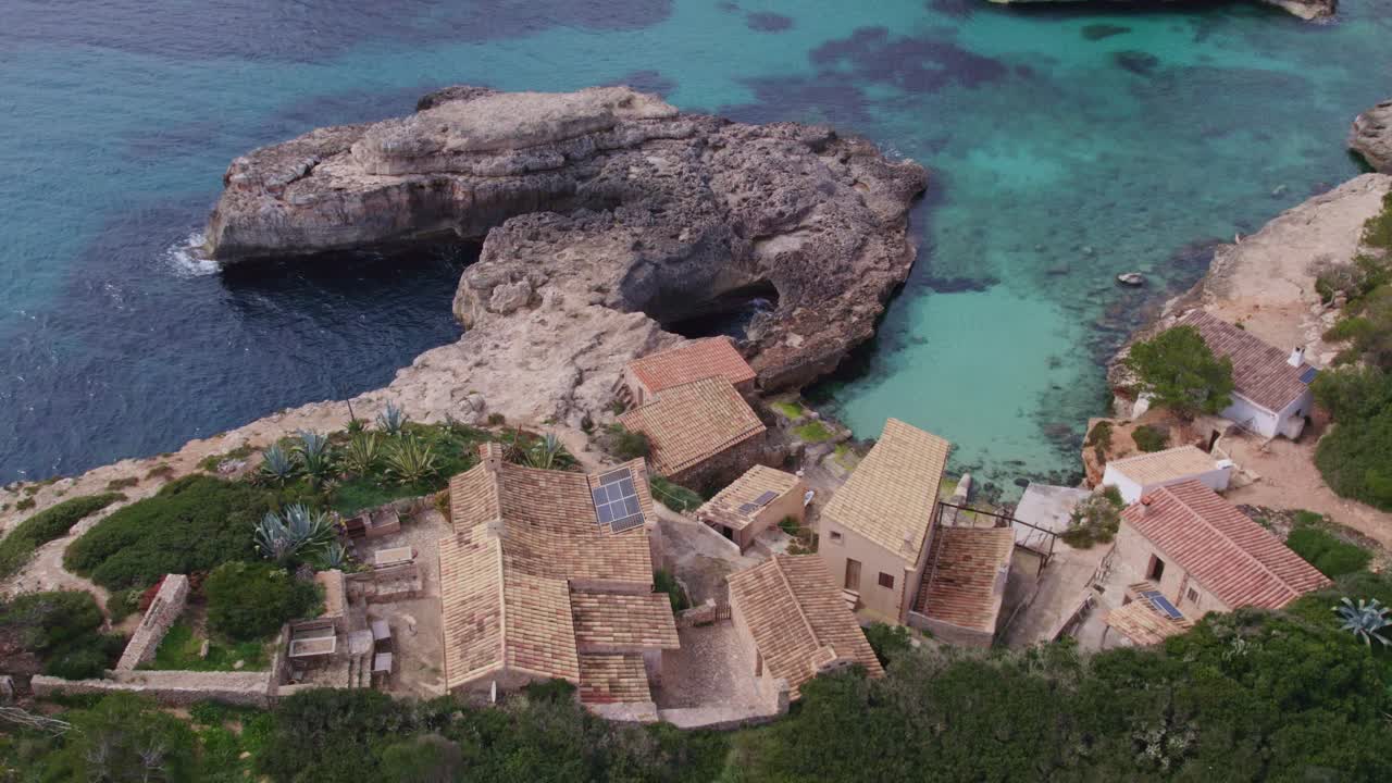 Reveal shot of small houses at S'Almonia Mallorca with no people, aerial