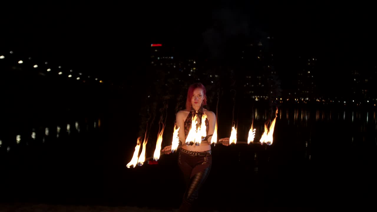 artista femenina creando círculos de fuego girando ventiladores