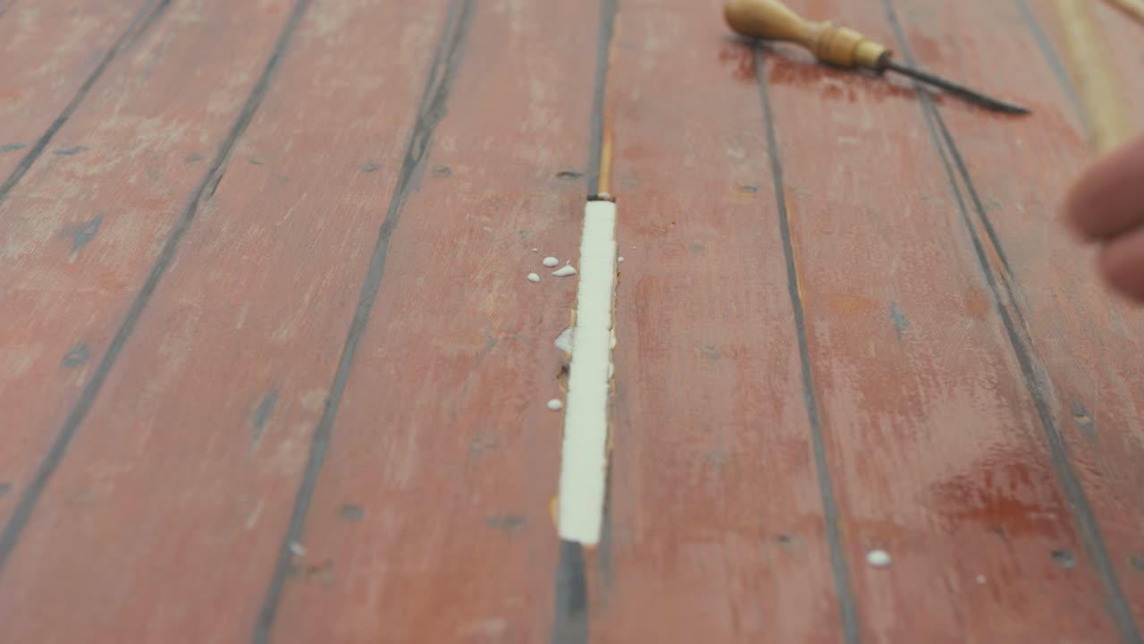 Fitting wooden spline insert into wooden roof planking on boat