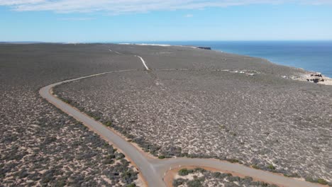 drone panorámica aérea que muestra una caravana en un largo camino por un hermoso océano