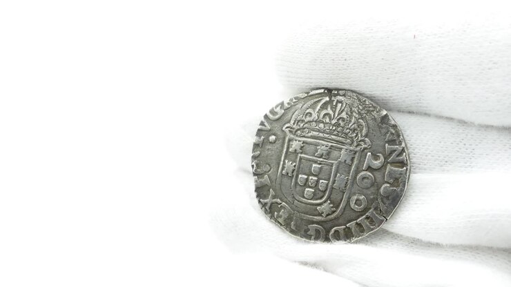 Numismatico con guanti bianchi che esamina una vecchia moneta 37