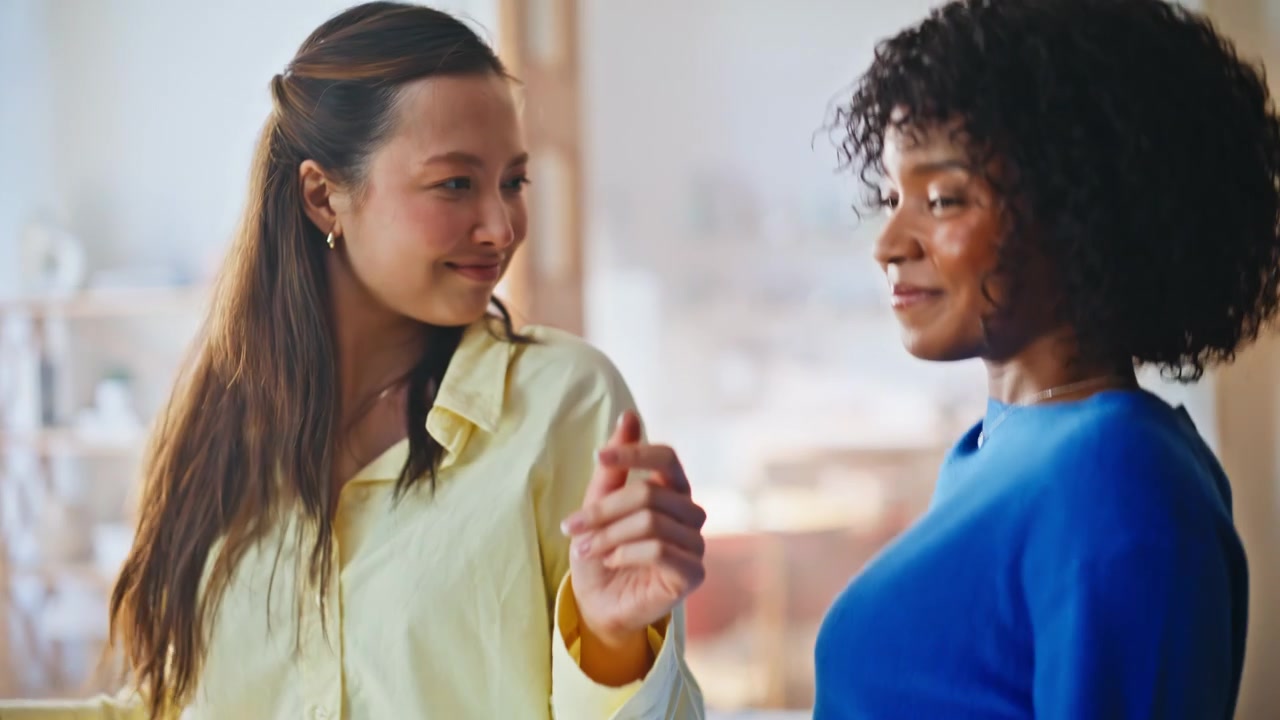 Multiracial roommates dancing home closeup. Cheerful women celebrating indoors.
