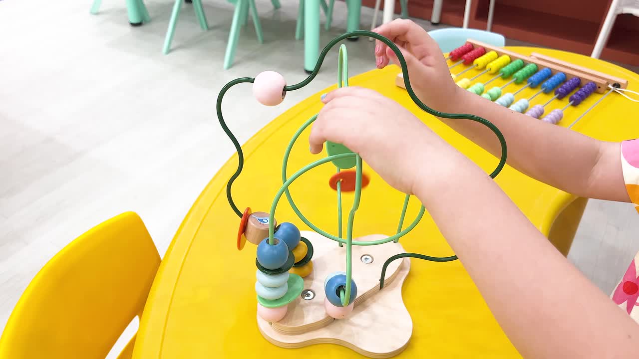 놀이터에서 구슬 미로와 상호 작용하는 아이들