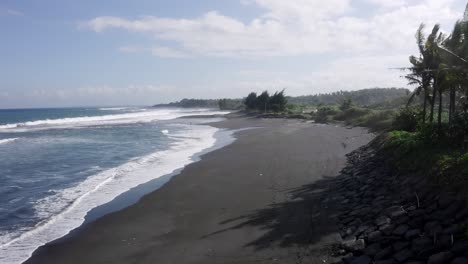 Drone-flying-low-over-shoreline-showing-calm-and-low-tides-moving-towards-the-shore-at-beach