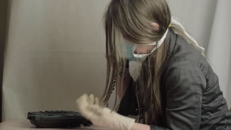 mujer con guantes quirúrgicos y mascarilla usando un teléfono de plano medio.