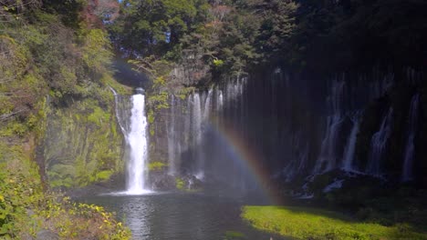 wide view of beautiful waterfalls in slow motion with vibrant rainbow