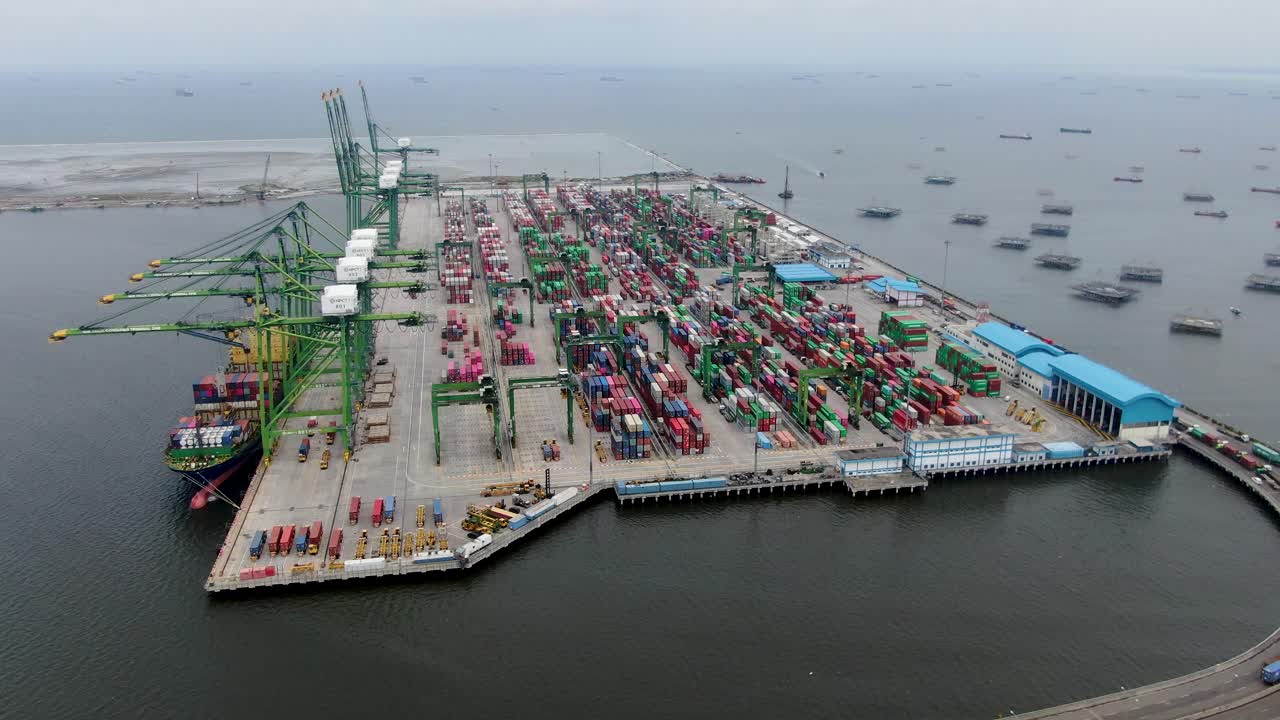 antena giratoria de puerto industrial, camiones y mar abierto en indonesia