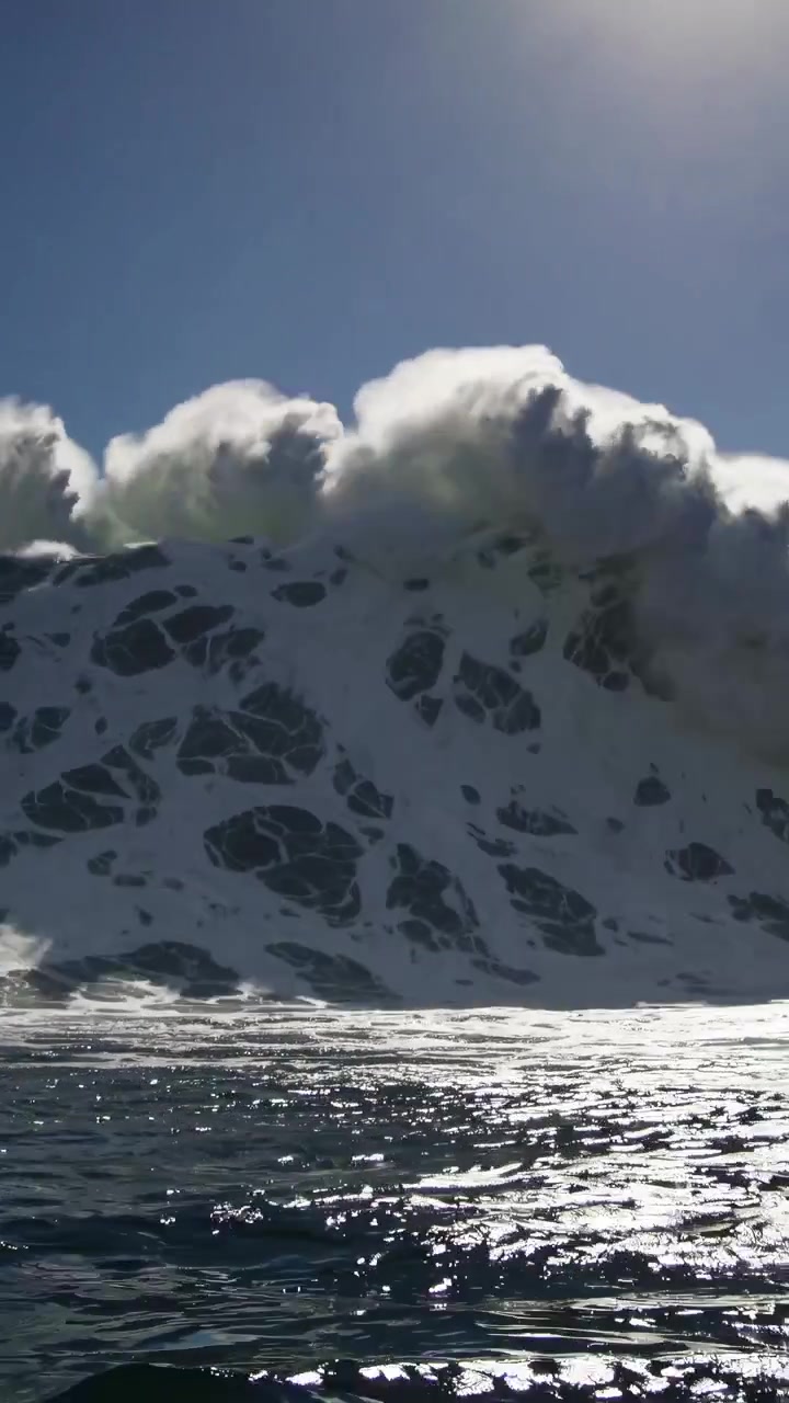 Powerful Ocean Wave Crashing Under a Clear Blue Sky