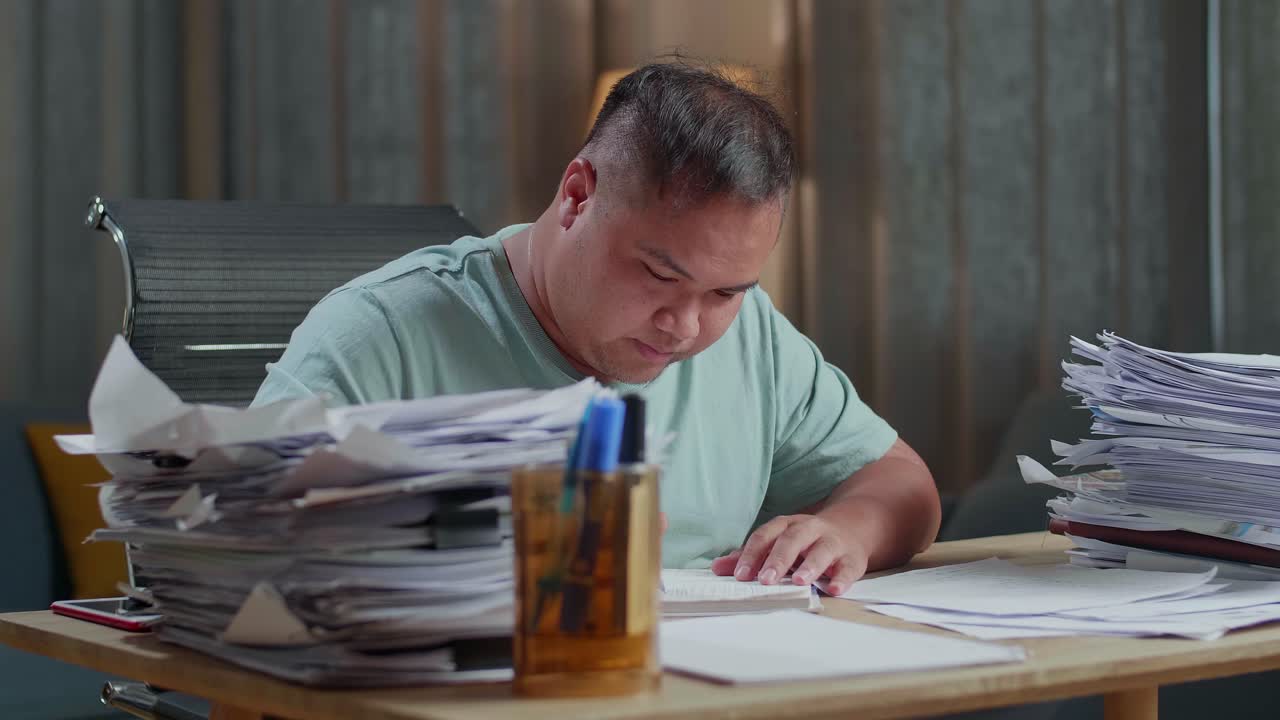 Close Up Of Fat Asian Man Working Hard With Documents At The Office